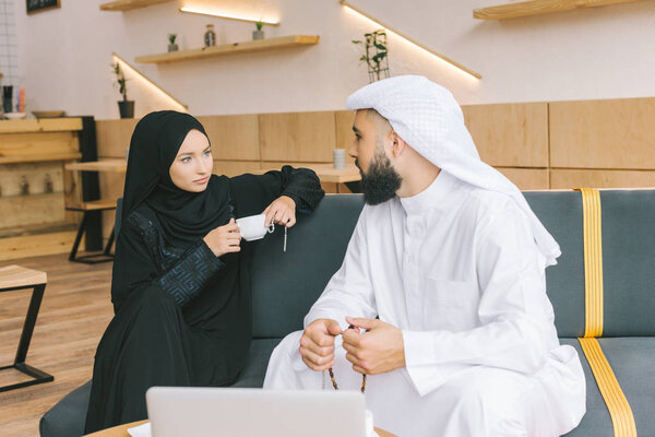 muslim couple spending time in cafe