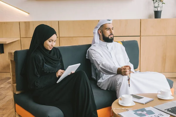 Muslim couple sitting on couch — Stock Photo, Image