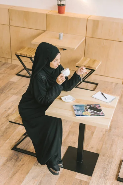 Muslim woman drinking coffee — Free Stock Photo