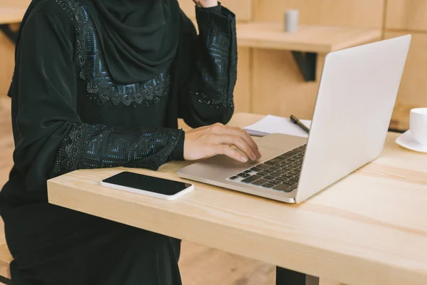 Muslim woman using laptop in cafe — Stock Photo, Image