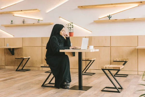 Muslim woman using laptop in cafe — Stock Photo, Image