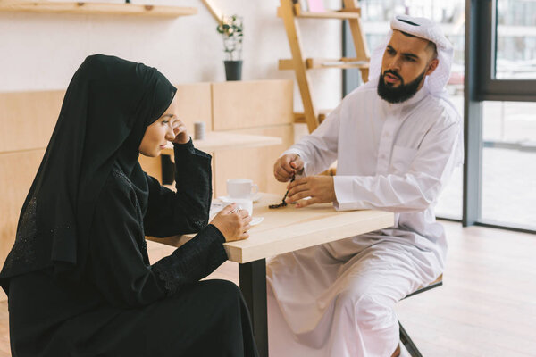 muslim couple having argument in cafe