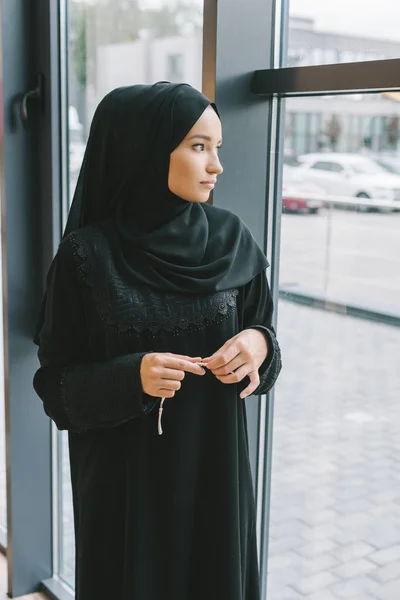 Muslim woman looking at window — Stock Photo, Image