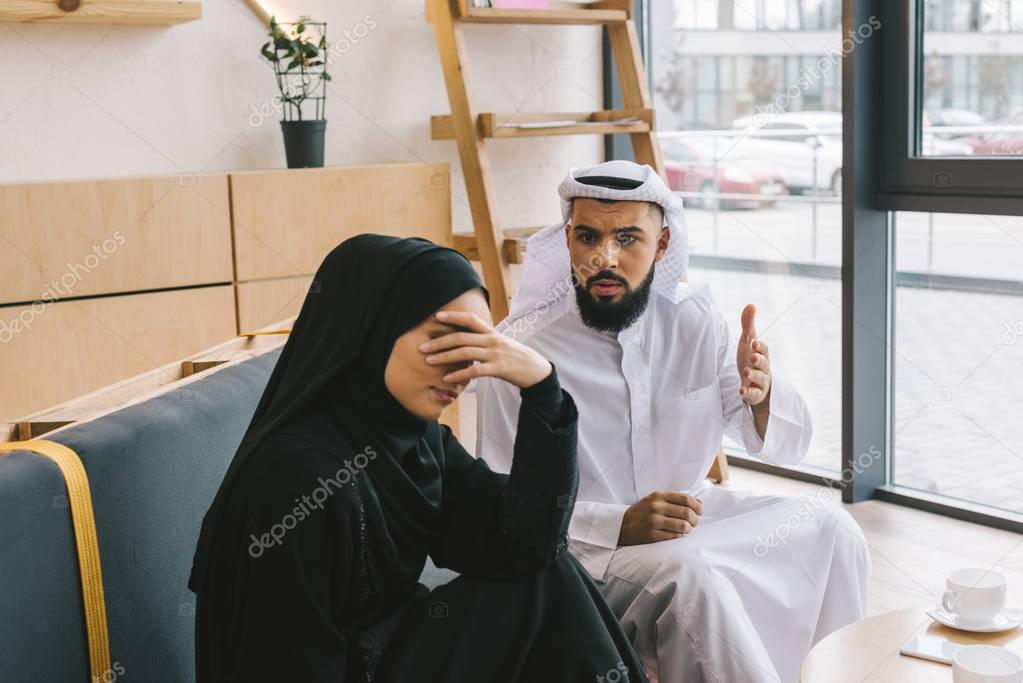 muslim couple having argument in cafe