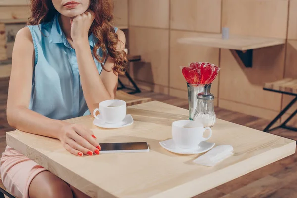 Mujer sentada en la mesa en la cafetería — Foto de Stock