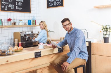 Kafede gazete okuyan bir adam.