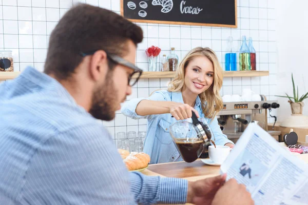 Waitress pouring coffee to client — Stock Photo, Image