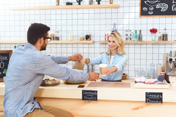 Serveerster en client met koffie te gaan — Stockfoto