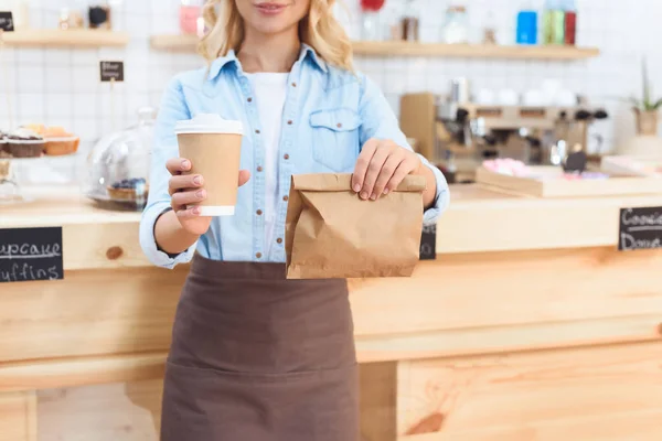 Waitress holding coffee to go — Stock Photo, Image