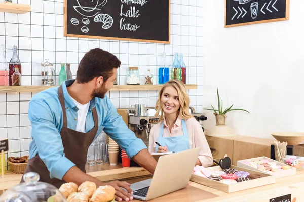 Cafe owners using laptop — Stock Photo, Image