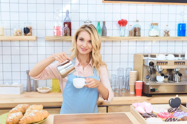 Barista pouring milk into coffee — Stock Photo, Image