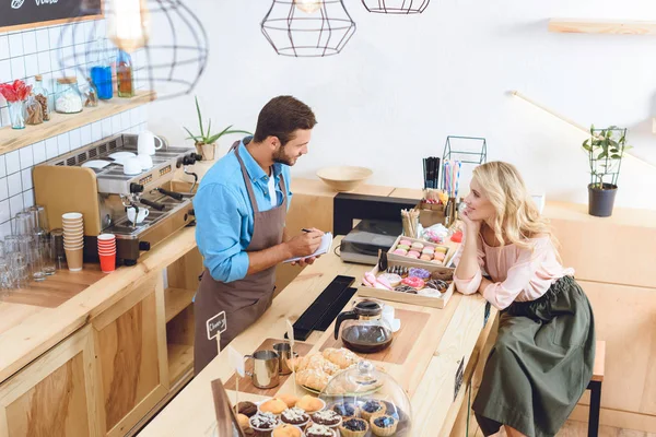 Waiter with notebook and smiling woman — Stock Photo, Image