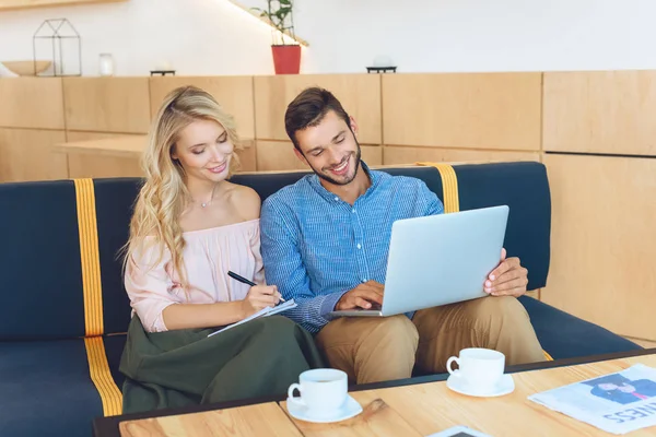 Pareja usando portátil en la cafetería — Foto de Stock