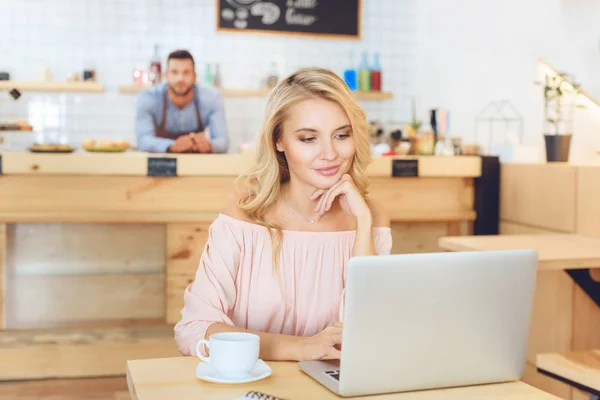 Kvinna som använder laptop i café — Stockfoto