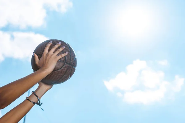 Female hands holding basketball — Stock Photo, Image