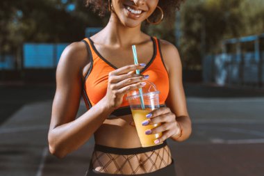athletic african-american woman drinking juice clipart