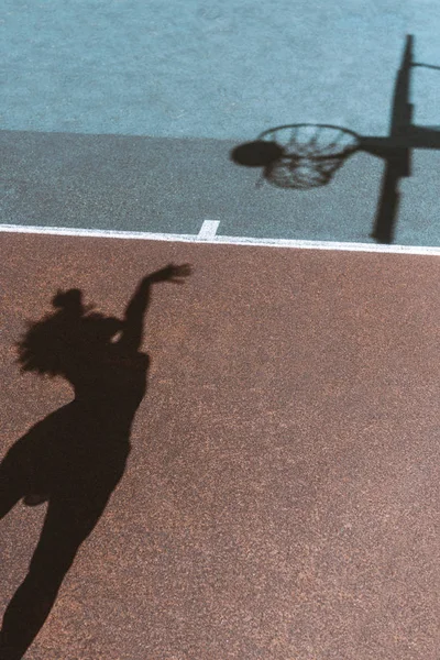 Shadow of woman throwing ball — Stock Photo, Image