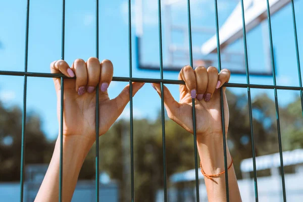 Hands clinging onto fencing — Stock Photo, Image