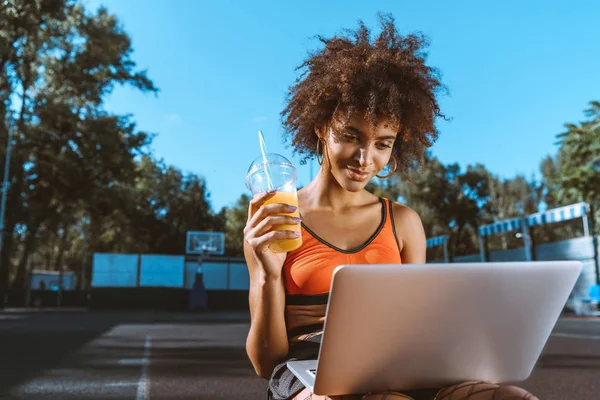 African-american woman with laptop and juice — Stock Photo, Image