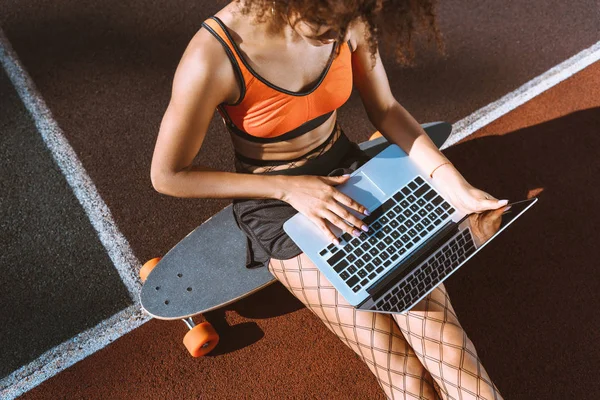 African-american woman on longboard with laptop — Stock Photo, Image