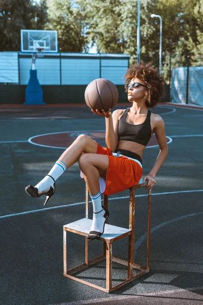 Wanita yang memegang bola basket di lapangan olahraga — Foto Stok Gratis