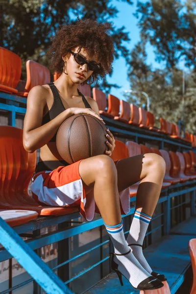 Mulher afro-americana em arquibancadas com basquete — Fotografia de Stock