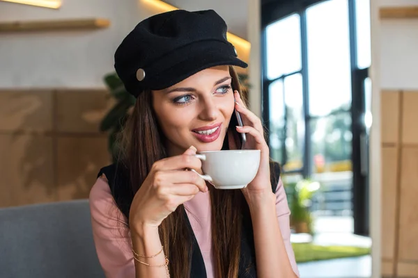 Mädchen mit Smartphone trinkt Kaffee — kostenloses Stockfoto