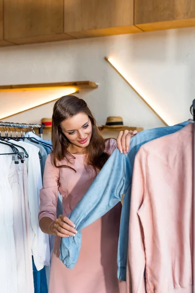 Mujer joven eligiendo ropa en boutique — Foto de stock gratis