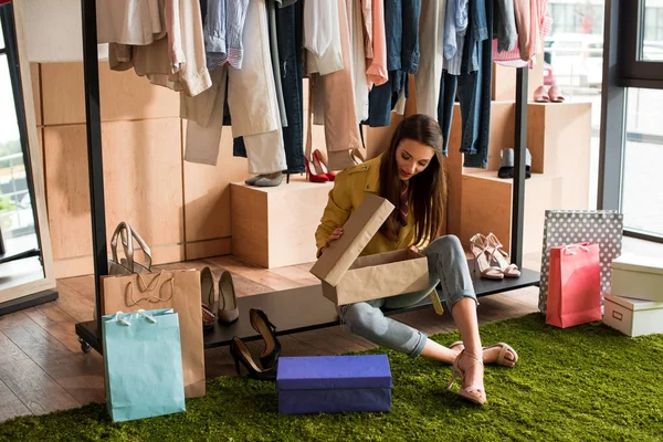 Junge Frau wählt Schuhe — Stockfoto