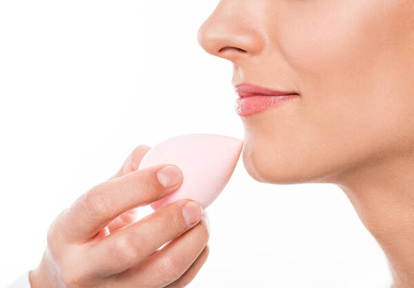 Визажист, накладывающий основы на лицо
