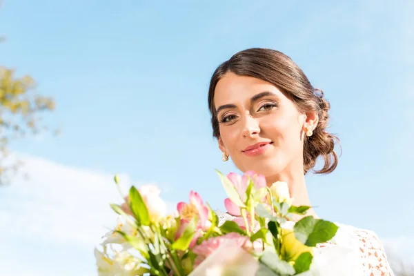 Beautiful woman with bouquet of flowers — Stock Photo, Image