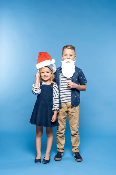 Kinder mit Weihnachtsmütze und falschem Bart — Stockfoto