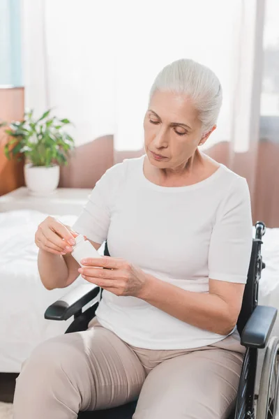 Donna sulla sedia a rotelle che prende la medicina — Foto Stock