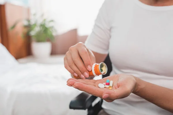 Mujer en silla de ruedas tomando medicamentos —  Fotos de Stock