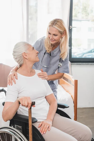 Sjuksköterska och senior kvinna i rullstol — Stockfoto