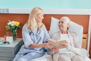 Hemşire ve kıdemli hasta kitap ile