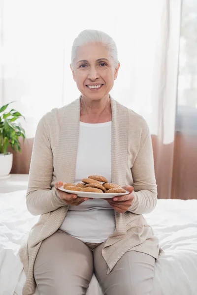 Hastanede kurabiyeyle kadın kıdemli — Stok fotoğraf