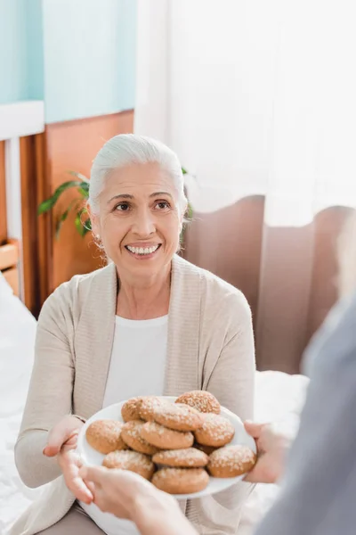 Sjuksköterska och patient med cookies — Stockfoto