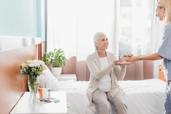 Nurse and patient with cookies — Stock Photo, Image