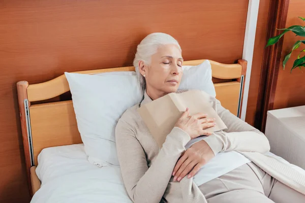 Mujer mayor con libro en el hospital — Foto de Stock