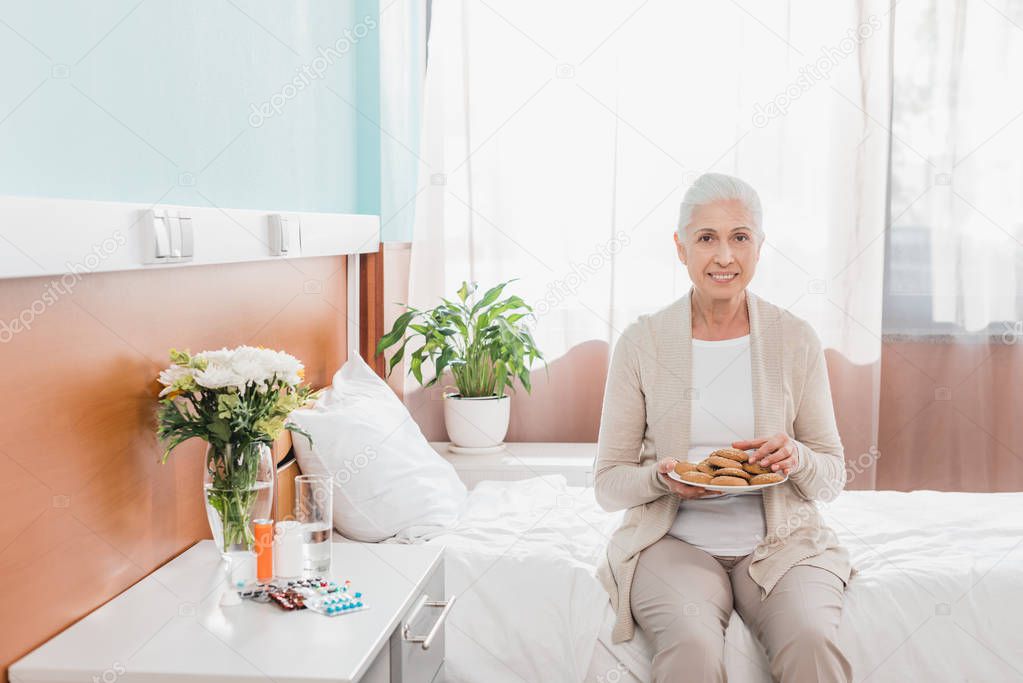 senior woman with cookies in hospital