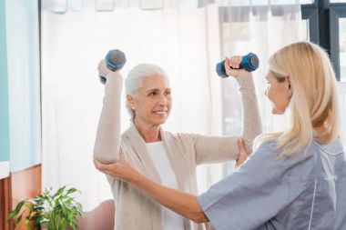 Hemşire ve üst düzey kadın dumbbells ile