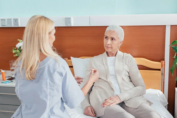 Nurse measuring temperature of patient — Stock Photo, Image