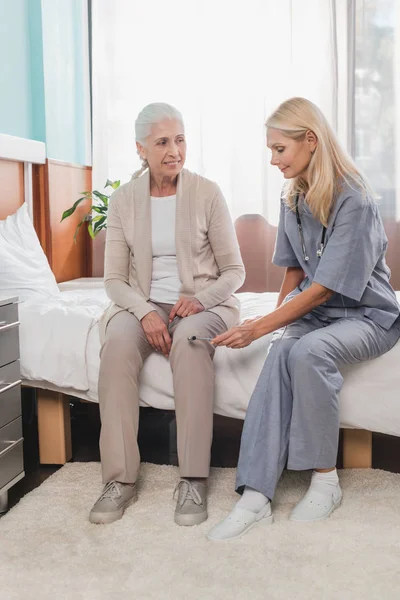 Медсестра осматривает пациента рефлекторным молотком — стоковое фото