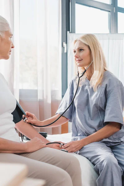 Enfermeira medir a pressão arterial para o paciente — Fotografia de Stock