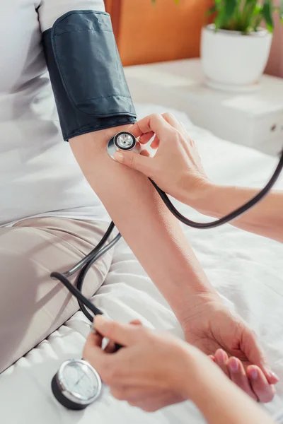 Nurse measuring blood pressure to patient — Stock Photo, Image