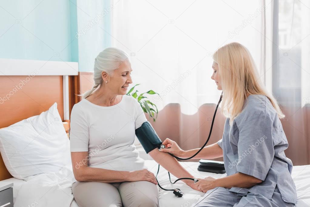 nurse measuring blood pressure to patient