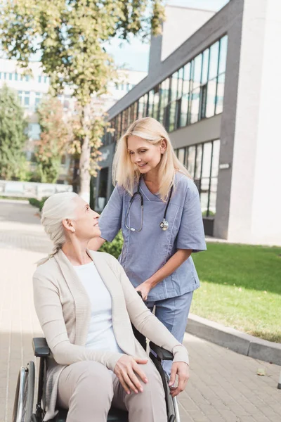 Sjuksköterska och senior kvinna i rullstol — Stockfoto