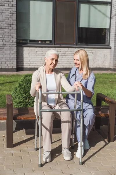 Verpleegkundige en senior patiënt met walker — Stockfoto