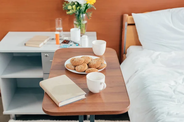 Soubory cookie a kniha v nemocničním pokoji — Stock fotografie